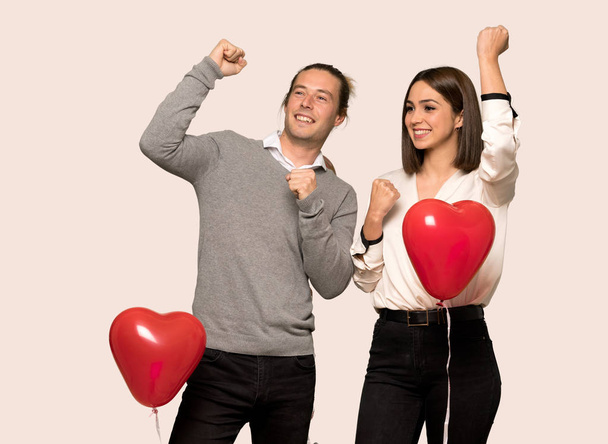 Couple in valentine day celebrating a victory over isolated background - Photo, Image