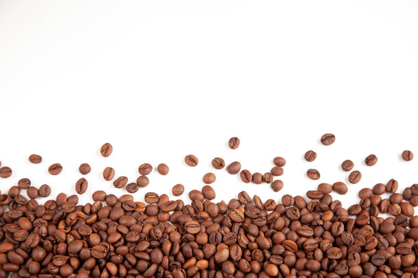 Textured brown coffee beans on a white background. - Foto, imagen