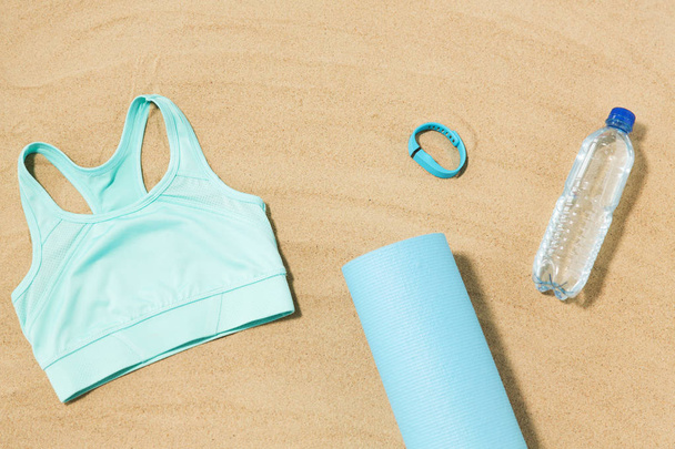 sports top, mat, fitness tracker and water bottle - Foto, immagini