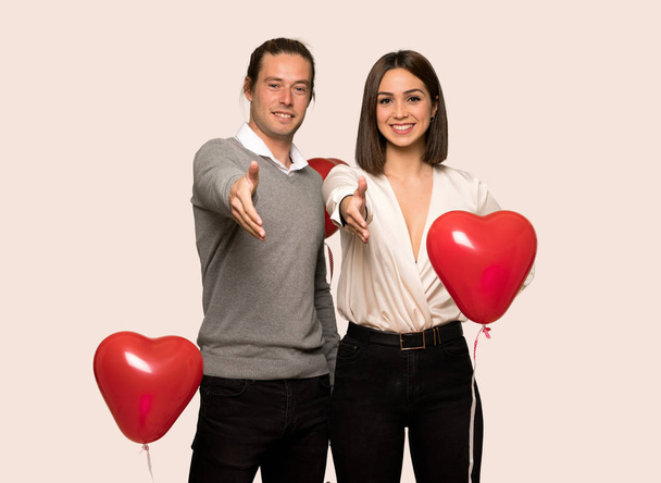 Couple in valentine day shaking hands for closing a good deal over isolated background - Photo, Image