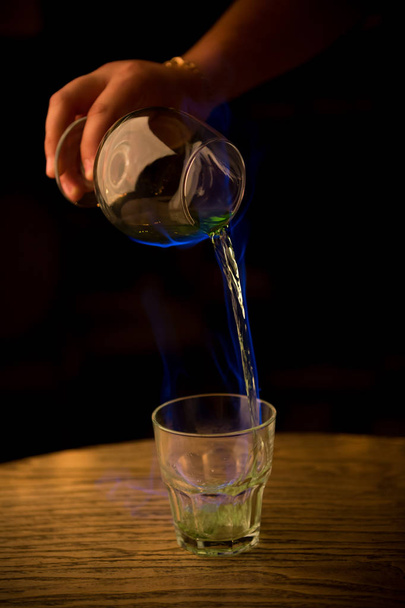 Μπάρμαν ρίχνει καύση αψέντι στο ποτήρι - Φωτογραφία, εικόνα