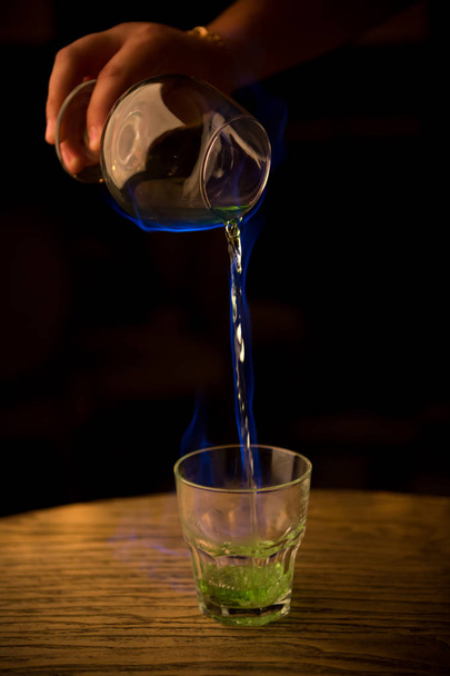 Bartender pouring burning absinthe in a glass - Photo, Image