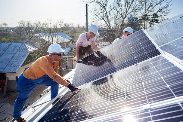 Ingénieurs masculins installant un système autonome de panneaux solaires photovoltaïques
 - Photo, image
