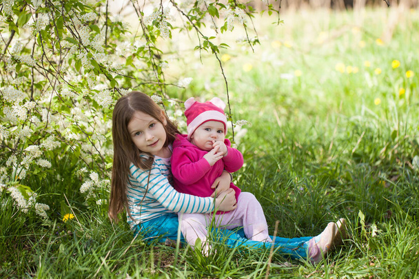 Nette Mädchen in einem blühenden Vogel Kirschbaum Garten - Foto, Bild
