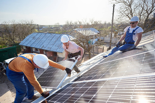 Operai maschi che installano pannelli fotovoltaici solari di giorno
 - Foto, immagini