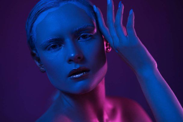 Young Pretty Woman with Cool Make Up. Neon Blue and Purple Lights on Face. - Fotografie, Obrázek