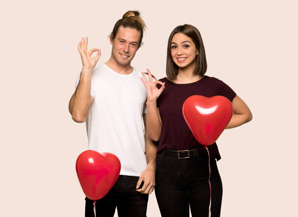 Koppel in de dag van de Valentijnskaart een ok teken met vingers tonen over geïsoleerde achtergrond - Foto, afbeelding