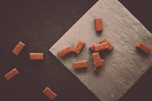 Γλυκό Ελβετική σοκολάτα καραμέλες στο πέτρινο tabletop, flatlay - επιδόρπια, ζαχαροπλαστική και έννοια χωρίς γλουτένη βιολογικά τρόφιμα. Το μόνο που χρειάζεστε είναι σοκολάτα - Φωτογραφία, εικόνα