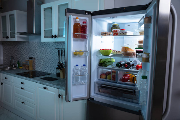 An Open Refrigerator Full Of Fruits, Juice And Fresh Vegetables In Kitchen - Фото, зображення