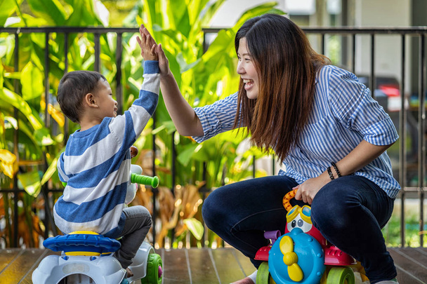 Asian single mom with son are playing with car toy and give me five together when living in modern house for Self learning or home school, Family and single mom concept, selective focus - Photo, Image