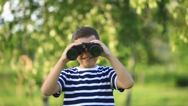 Menino caminhando no parque e olhando através de binóculos
 - Filmagem, Vídeo