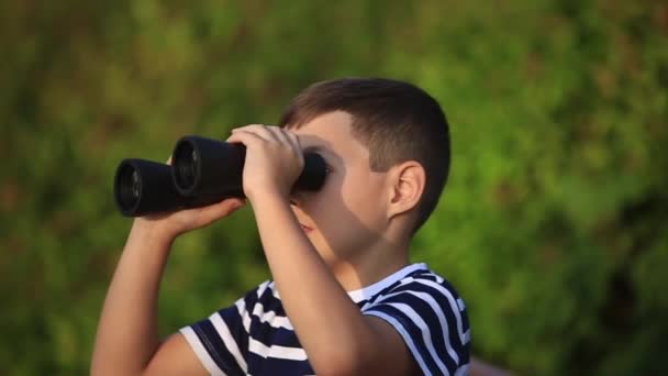 Jongetje in het park wandelen en op zoek door middel van verrekijkers - Video