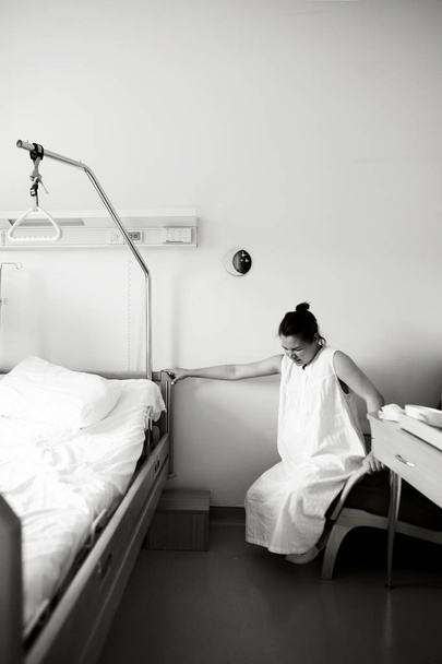 The woman has a scramble and it hurts her. Woman trying to get up from the chair in the maternity hospial - Фото, зображення