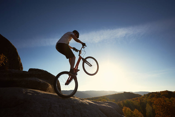sziluettjét sportoló kerékpáros kiegyensúlyozó a hátsó kerék a tárgyalás kerékpár - Fotó, kép