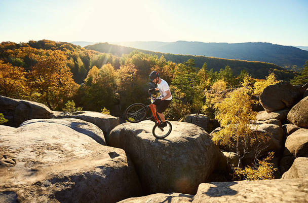大きな岩の上に自転車で分散裁判に若い男性サイクリスト - 写真・画像