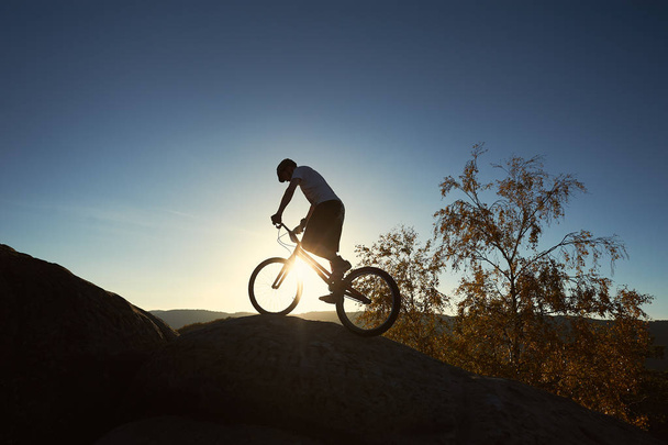 Sportler balanciert auf Hinterrad auf Trial-Fahrrad - Foto, Bild