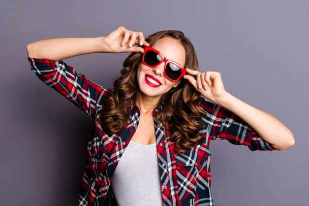 Close up portrait of attractive she her lady holding hands on red dark bright summer glasses specs ready to go to airport railway bus wearing checkered shirt isolated on grey background - Фото, изображение