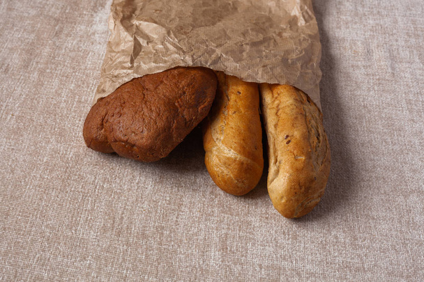 Другой хлеб чабатта без дрожжей. Свежий хлеб на бумажном фоне. Концепция здорового питания
. - Фото, изображение