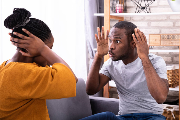 An Angry Young Man Scolding To His Wife Covering Ears At Home - Foto, immagini