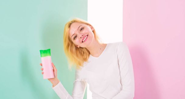Lady blonde holds shampoo bottle. My hair care secret. Woman happy smiling face shows beauty product for hair, copy space. Beauty treatment product. Girl holds shampoo bottle recommends use product - Φωτογραφία, εικόνα