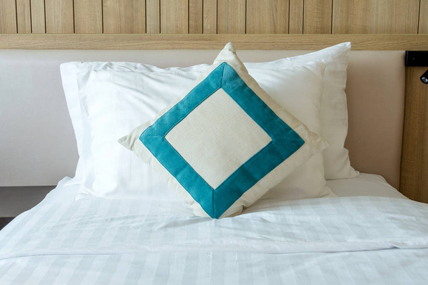 寝室の装飾的な枕と乱雑な白いベッドの掛け布団 - 写真・画像