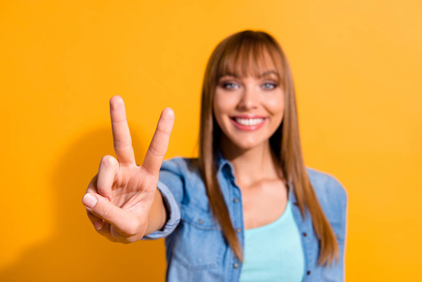 Close-up portrait of her she nice cute sweet lovely gorgeous attractive winsome cheerful straight-haired lady showing v-sign isolated over bright vivid shine yellow background - Foto, imagen