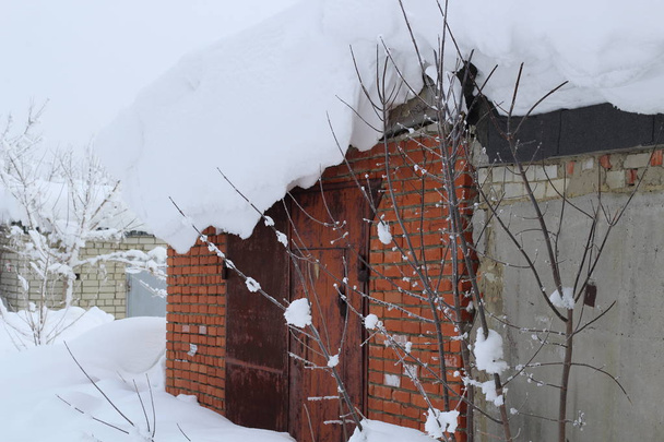 Снігова хвиля на даху гаража, утворена сильними вітрами, коли падає сніг
 - Фото, зображення