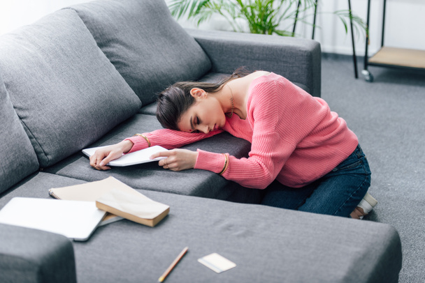exausto estudante indiano feminino dormindo no sofá com cadernos
 - Foto, Imagem
