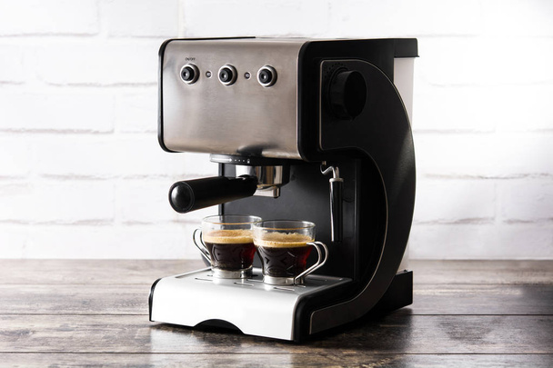 Fresh coffee in espresso coffee machine on wooden table - Fotoğraf, Görsel