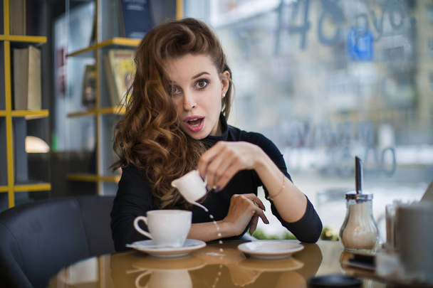 funny girl in the cafe spilled coffee. Coffee break concept. - Φωτογραφία, εικόνα