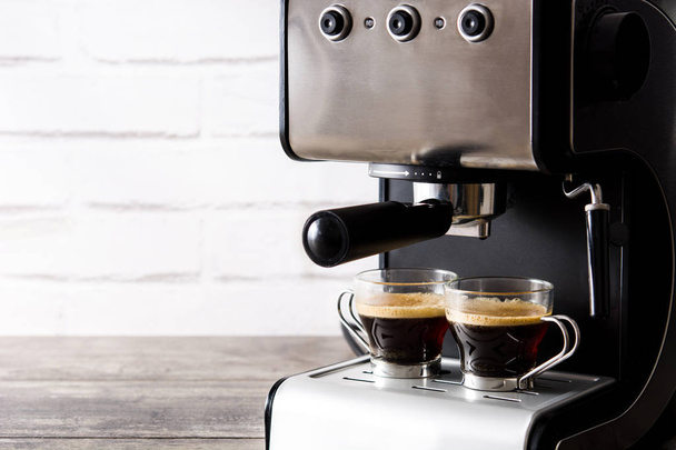 Свіжа кава в кавовій машині еспресо на дерев'яному столі
 - Фото, зображення