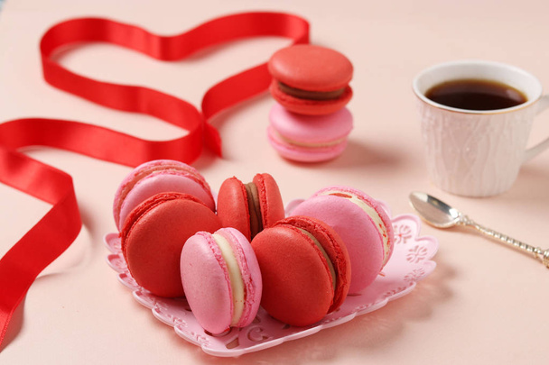 Deliciosos macarrones dulces en un plato figurado sobre un fondo rosa, macarrones rojos y rosados. Concepto para el Día de San Valentín, Cumpleaños, 8 de marzo y Día de la Madre
 - Foto, imagen