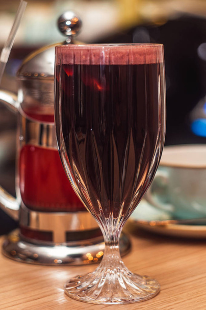 glas met warme zelfgemaakte glühwein op tafel, close-up - Foto, afbeelding