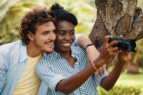 Happy boyfriend and girlfriend enjoying taking photos on camera - Foto, Imagen