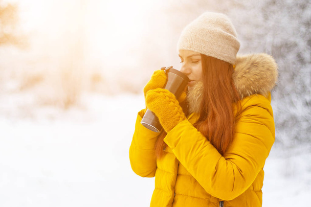 Χαριτωμένο κορίτσι που απολαμβάνει καφέ σε μια χειμερινή ημέρα.  - Φωτογραφία, εικόνα