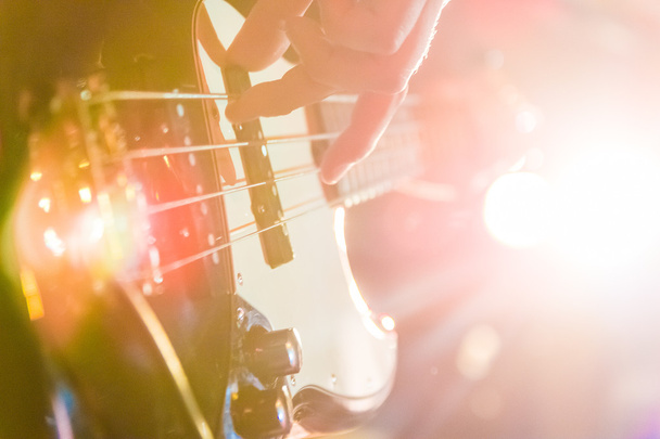 Чоловік грає на бас-гітарі в чорно-жовтому
 - Фото, зображення