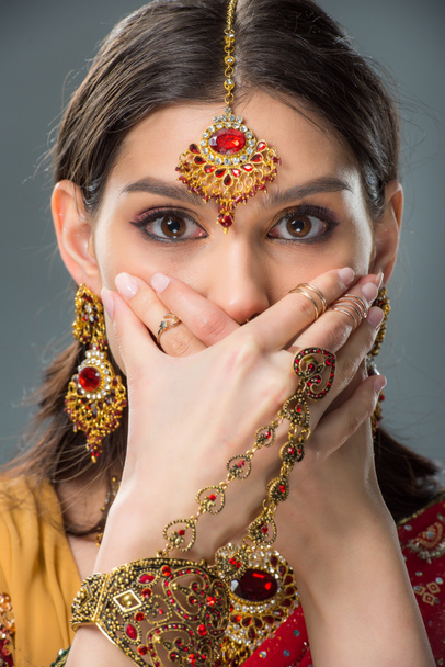 döbbenve indiai lány záró száj, kezével, elszigetelt szürke  - Fotó, kép