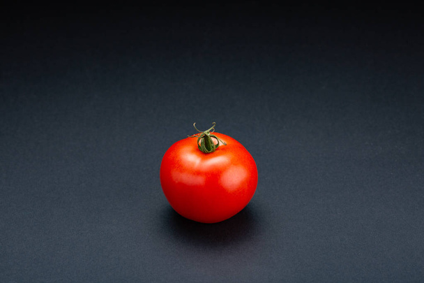 fresh Tomato on a black background with realistic reflection - Photo, Image