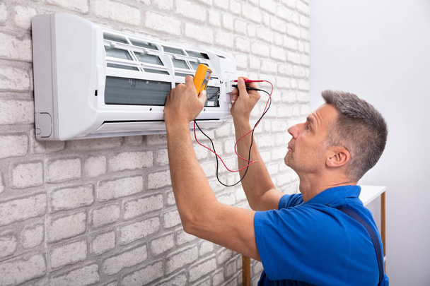Male Electrician Checking Air Conditioner With Digital Multimeter - Φωτογραφία, εικόνα