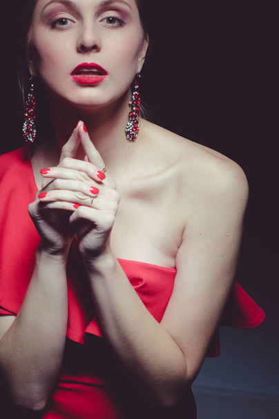 beautiful young caucasian woman wearing red dress posing at studio - Foto, afbeelding