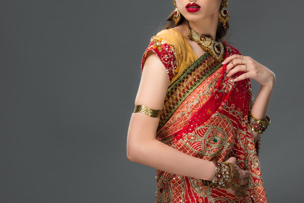 rajattu näkymä intialainen nainen poseeraa perinteisessä sari ja tarvikkeet, eristetty harmaa
  - Valokuva, kuva