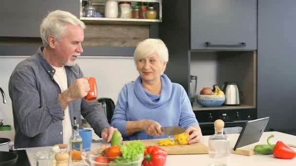 Happy senior couple preparing salad together. - Кадры, видео