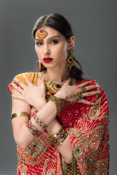 attractive indian woman posing in traditional sari and accessories, isolated on grey  - Foto, immagini