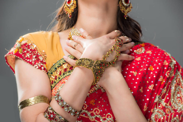 cropped view of indian woman posing in sari and accessories, isolated on grey  - Foto, afbeelding