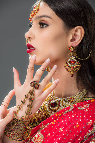όμορφη ινδική γυναίκα χειρονομώ στο αξεσουάρ, απομονώνονται σε γκρι  - Φωτογραφία, εικόνα