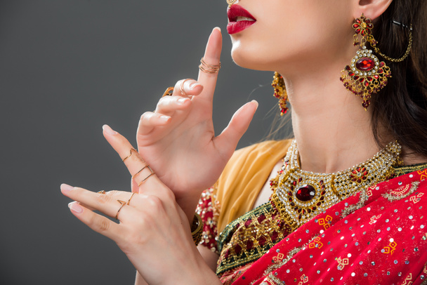 vista ritagliata di donna indiana gesticolando in accessori, isolato su grigio
  - Foto, immagini