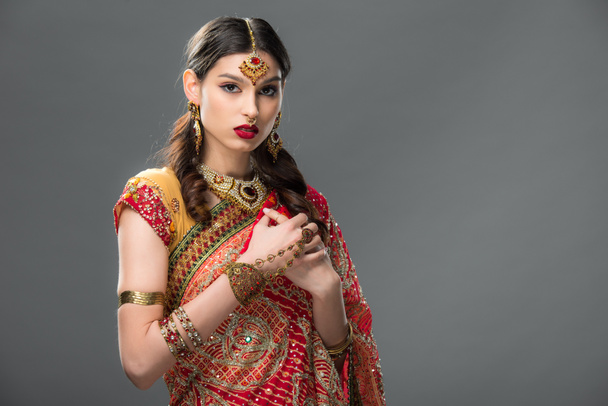 elegant indian woman in sari and accessories, isolated on grey  - Photo, image
