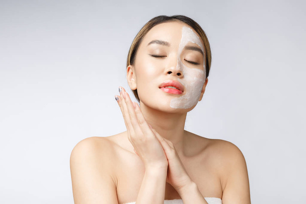 Charming pleasant woman applying cream on half face. - Фото, зображення