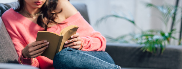 cropped view of female student reading book on sofa - Fotografie, Obrázek