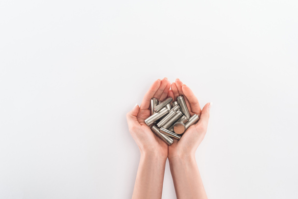 Cropped view of woman holding batteries on grey background - Foto, Bild